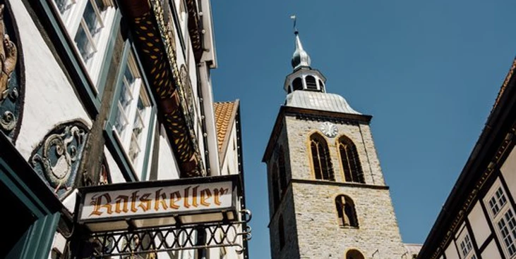 Ratskeller.jpg Historische Fachwerkhäuser und der markante Kirchturm von Lemgo bei strahlend blauem Himmel.