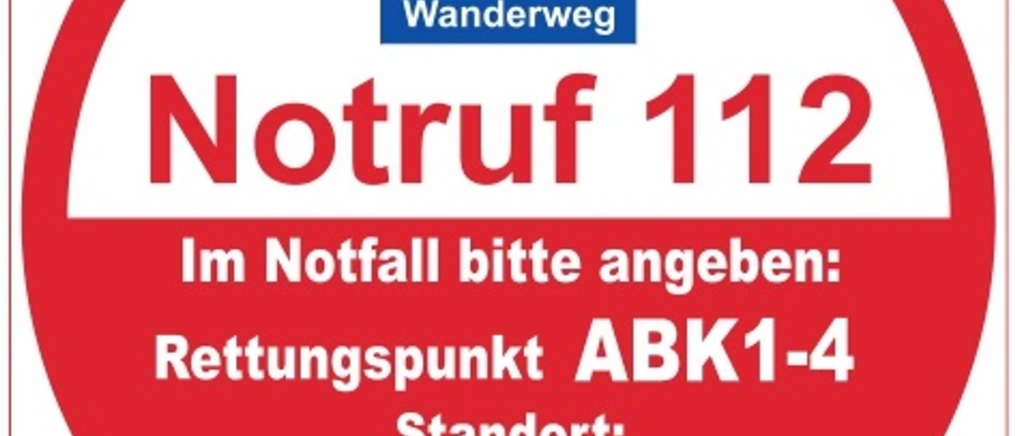 Rettungspunkt ABK1-4 Rundes Schild mit Hinweis auf Notrufnummer 112, Rettungspunkt ABK1-4 am Viadukt Wanderweg.