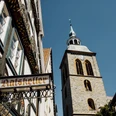 Fachwerkhäuser und der Kirchturm von St. Dionys bei sonnigem Himmel in Lemgo.