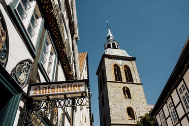 Bild 5.jpg Fachwerkhäuser und der Kirchturm von St. Dionys bei sonnigem Himmel in Lemgo.