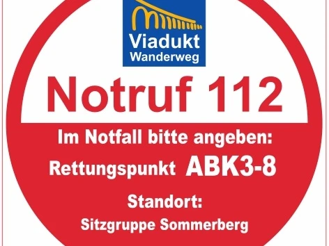 Roter Kreis mit Notrufnummer 112, Hinweis auf Rettungspunkt ABK3-8, bei Sitzgruppe Sommerberg.