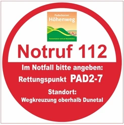 Runder Rettungspunkt-Aufkleber im Paderborner Höhenweg mit Notruf 112 und PAD2-7 für Notfälle.
