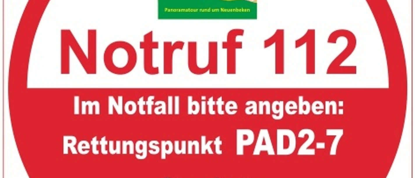 Runder Rettungspunkt-Aufkleber im Paderborner Höhenweg mit Notruf 112 und PAD2-7 für Notfälle.