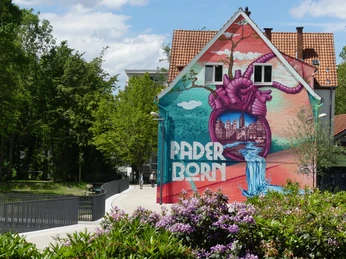 Farbprächtiges Graffiti an einer Hauswand im Mittleren Paderquellgebiet, symbolisiert Paderborn.