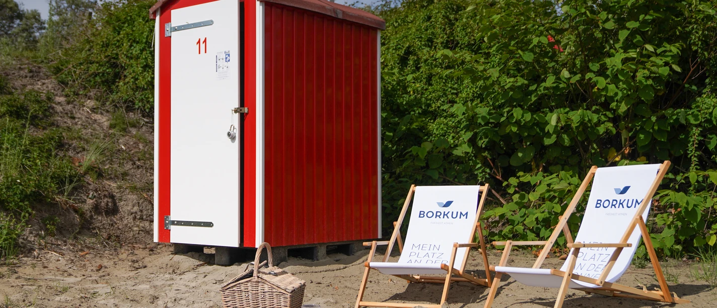 2021_06 - BA NBG FKK Budjes-2128.jpg Rote FKK-Bude, zwei weiße Liegestühle und Picknickplatz mit Decke, Korb und Weingläsern auf dem Boden