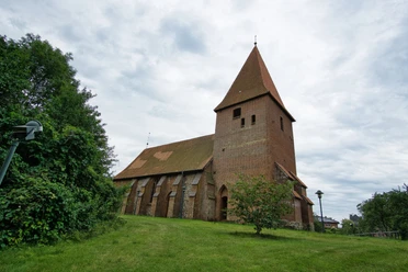 _DSC2573.jpg Die historische St. Martins-Kirche aus Backstein mit spitzem Turmdach steht auf einem grünen Hügel.