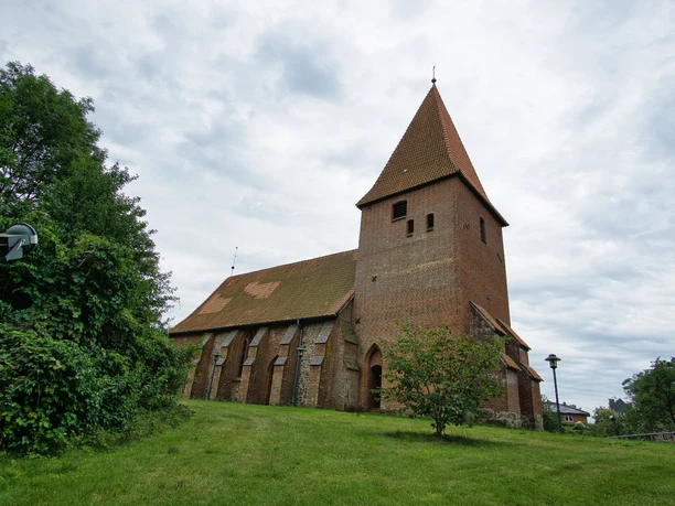 _DSC2573.jpg Die historische St. Martins-Kirche aus Backstein mit spitzem Turmdach steht auf einem grünen Hügel.
