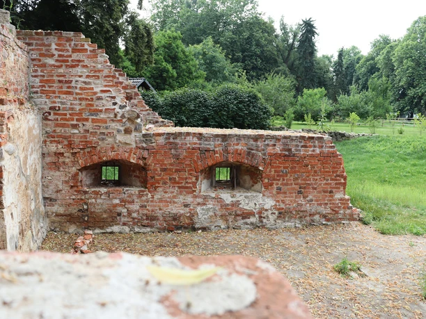 Ellerburg Ziegelruinen einer mittelalterlichen Burgmauer mit zwei Fensteröffnungen, umgeben von grüner Landschaft.