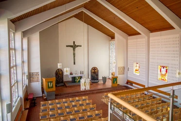 Gabriel-Kirche in Nettelstedt Innenraum der Gabriel-Kirche in Nettelstedt mit markantem Holzdach, schlichtem Altar und bunten Fenstern.