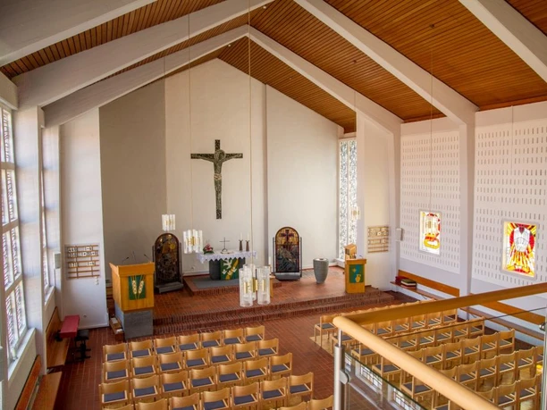 Gabriel-Kirche in Nettelstedt Innenraum der Gabriel-Kirche in Nettelstedt mit markantem Holzdach, schlichtem Altar und bunten Fenstern.