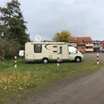 Wohnmobilstellplatz Steyerberg Wohnmobil auf grünem Stellplatz in Steyerberg, umgeben von Herbstlaub und nahe gelegenen Häusern.