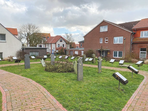 Der historische Walfängerfriedhof zeigt gepflegte Grabsteine, umgeben von sauberer Rasenfläche und charakteristischen Altbauten im Hintergrund. Ein Ort der Ruhe und Geschichte in malerischem Ambiente.The historic whalers' cemetery features well-kept gravestones, surrounded by clean lawns and characteristic old buildings in the background. A place of peace and history in a picturesque setting.