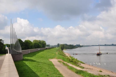 Deich Monheim am Rhein Grüner Deichabschnitt entlang des Rheins in Monheim, gesäumt von Wegen und ankernden Booten einstellen.