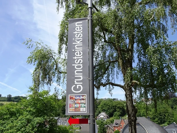 Straßenschild der Grundsteinkisten in Velbert-Langenberg Ein hohes Schild im Ortsteil Langenberg in Velbert wirbt für die Grundsteinkisten mit einem Hinweis.