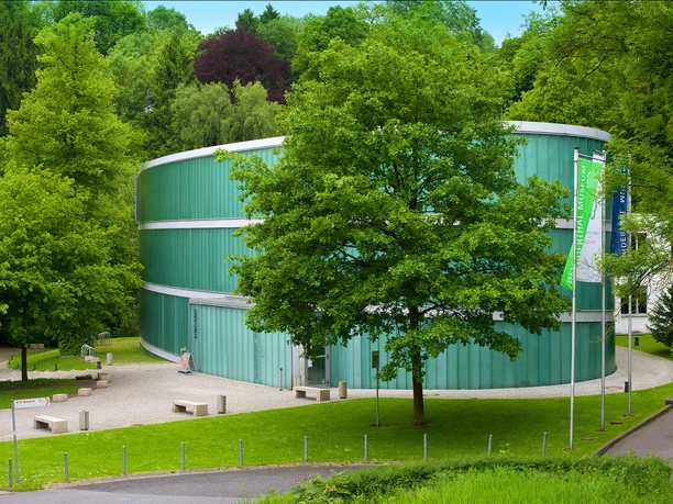 Gebäude Neanderthal Museum Modernes Museum mit transparenten Glasfassaden, umgeben von grünen Bäumen und einem gepflegten Hof.