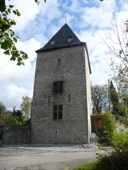 Schinderhannesturm in Schöller Der steinerne Schinderhannesturm in Schöller erhebt sich markant mit einem hohen, spitzen Dach.