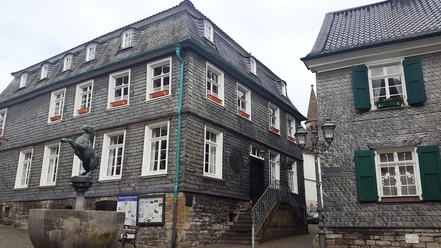 Außenansicht Alte Bürgermeisterei und Stadtgeschichtshaus Mettmann Alte Bürgermeisterei und Stadtgeschichtshaus Mettmann mit Statue und Infotafel im Vordergrund.
