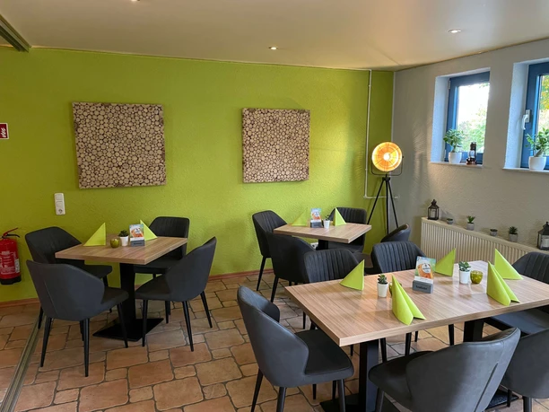 Basilico-1.jpg Modern eingerichteter Gastraum mit drei Tischen