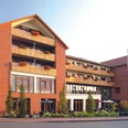 Landhotel Rotes Backsteingebäude mit mehreren Stockwerken, Balkonen und großen Fenstern in ruhiger Umgebung.