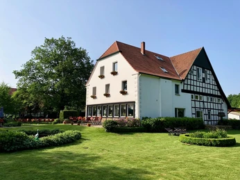 Landhaus Röscher Landhaus Röscher mit Fachwerkdetails, umgeben von gepflegtem Garten und großer Terrasse im Grünen.