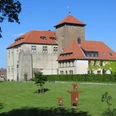 Burg Horn Burg Horn thront majestätisch auf einer Wiese mit rotem Ziegeldach und Umgeben von grünen Bäumen.