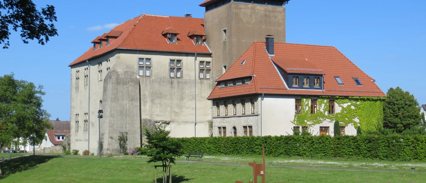 Burg Horn Burg Horn thront majestätisch auf einer Wiese mit rotem Ziegeldach und Umgeben von grünen Bäumen.