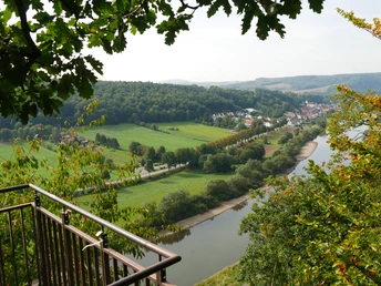 Eine Metallplattform bietet eine atemberaubende Aussicht auf die Weserlandschaft mit Fluss, Wäldern und Dörfern.