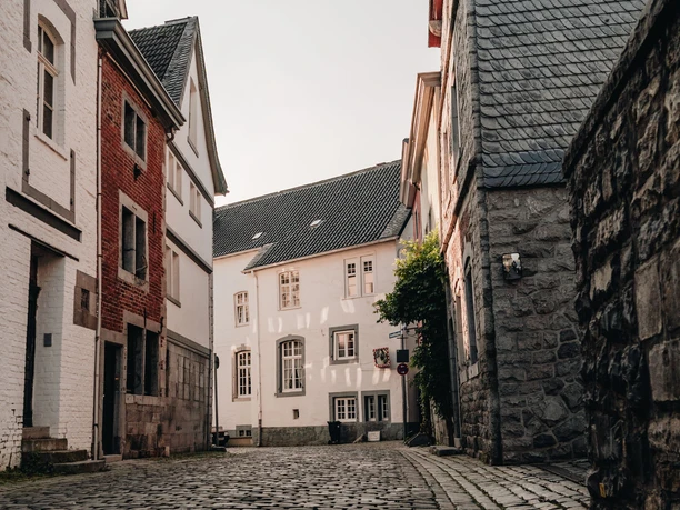 Kornelimuenster Straße Historische Kopfsteinpflasterstraße zwischen alten Gebäuden.