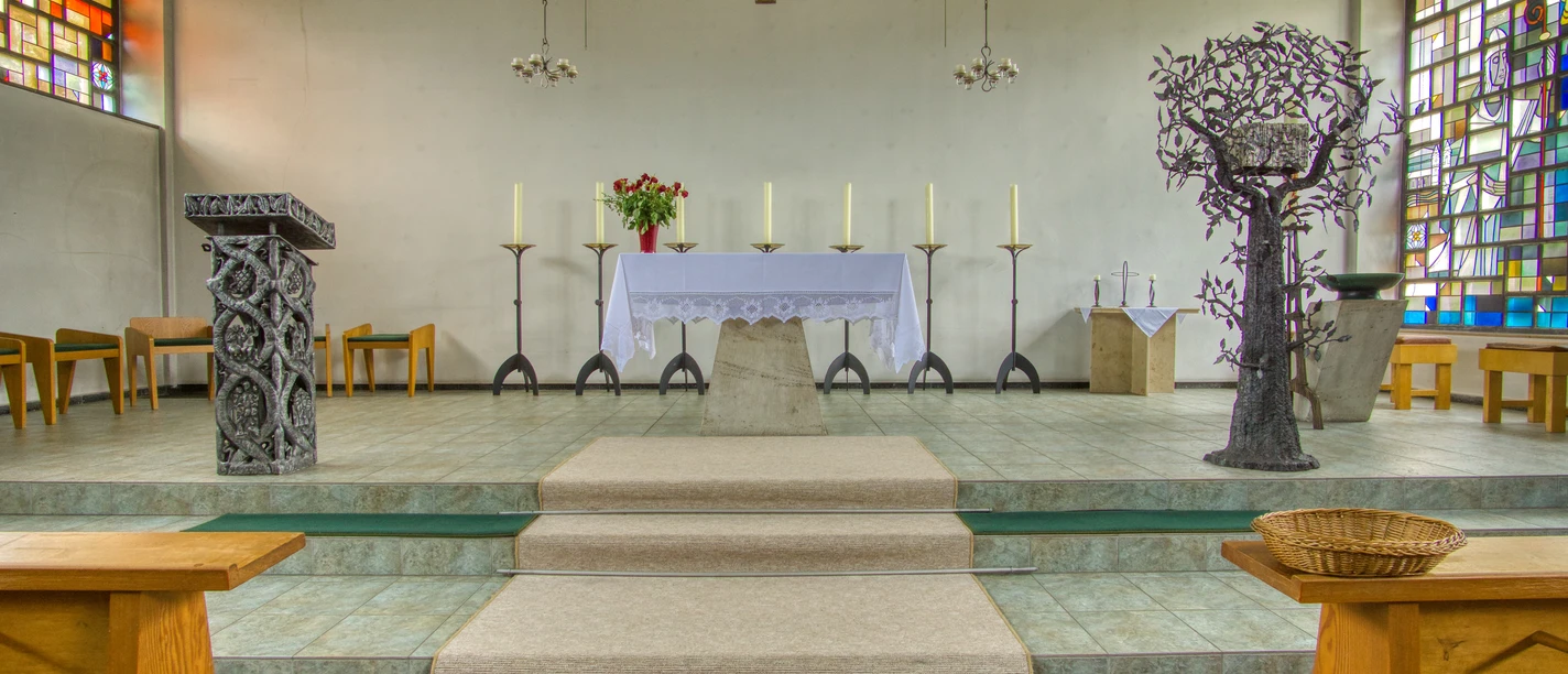Kath. Kirche altar.jpeg Altarraum der St. Godehard Kirche mit modernem Ambo, Altar und bunten Bleiglasfenstern.