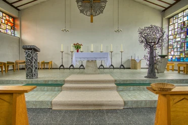 Kath. Kirche altar.jpeg Altarraum der St. Godehard Kirche mit modernem Ambo, Altar und bunten Bleiglasfenstern.