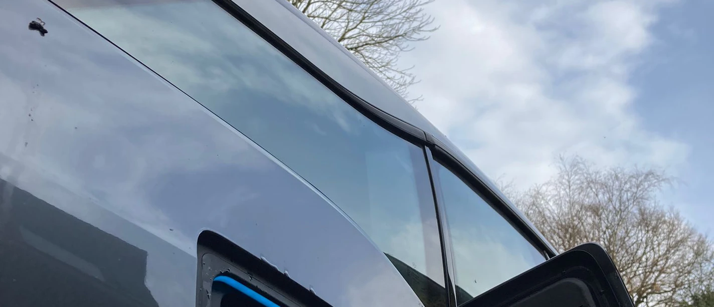 Ladestation Elektroauto Ein Elektrofahrzeug wird von außen beim Ladevorgang unter bewölktem Himmel gezeigt.