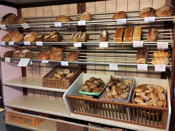 Auslage im Markt Café. Zu sehen sind Brötchen und diverse Brote im Regal.