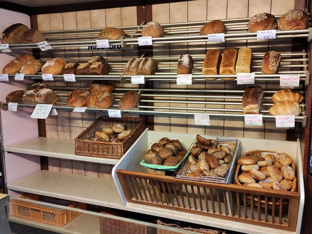 Auslage im Markt Café. Zu sehen sind Brötchen und diverse Brote im Regal.