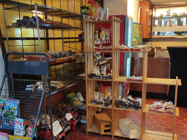 Regal mit Zeitschriften, Weihnachtsgebäck und alltäglichen Lebensmitteln