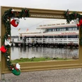 winter-wunder-welt-2021-bilderrahmen.jpg Weihnachtlich geschmückter Bilderrahmen mit Blick auf das Fahrgastschiff Bad Zwischenahn am See.