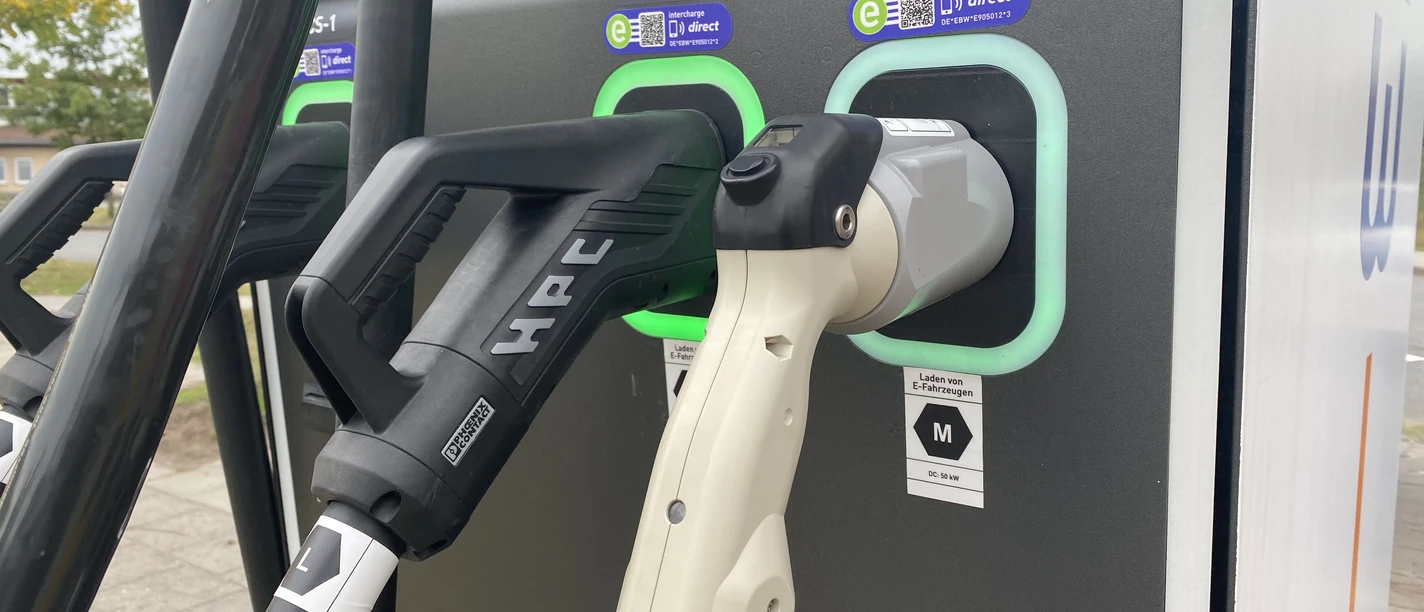 Symbolbild: E-Tankstelle Zwei Ladestecker für Elektrofahrzeuge an einer öffentlichen Ladestation im Freien.
