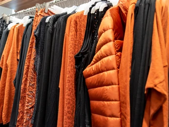 Tredy-1.jpg Klamotten auf einer Kleiderstange in orange und schwarz