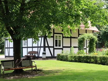 Kurpark Rothenuffeln Fachwerkhaus im Kurpark Rothenuffeln, umgeben von Bäumen und einer gepflegten Grünfläche mit Bank.