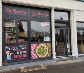 Außenansicht La Rustica, auf dem Fenster stehen Angebote