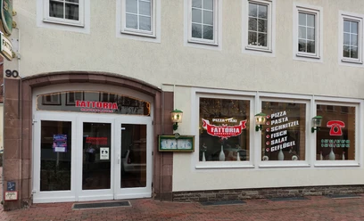 Außenansicht eines Restaurants mit großem Schaufenster, das italienische Gerichte wie Pizza und Pasta anbietet.