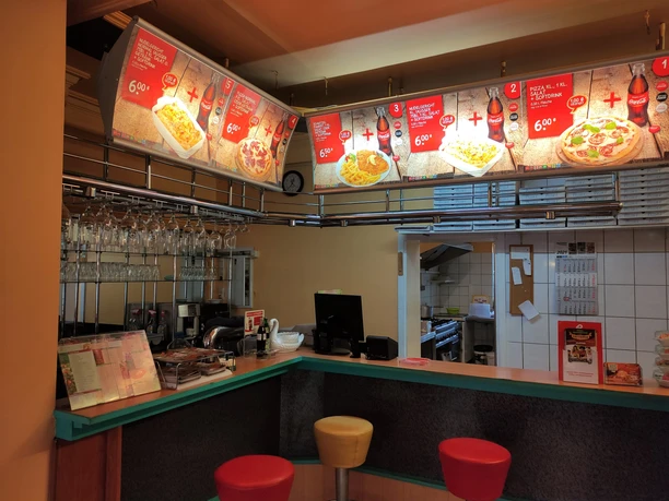 Bestelltresen im Restaurant Fattoria. Im Hintergrund ist die Speisekarte zu sehen