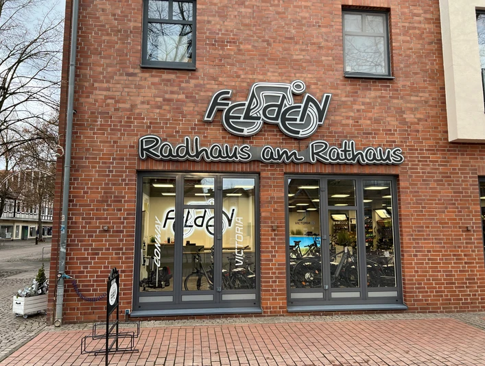 Radhaus am Rathaus Fahrradgeschäft mit moderner Backsteinfassade und großen Fenstern, zeigt Fahrräder im Inneren.
