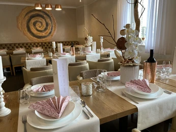 Dissen_Eventhaus Schamin_gedeckter Tisch_W_Schamin.jpg Ein stilvoll gedeckter Speisesaal mit elegant gefalteten Servietten und dekorativen Elementen.