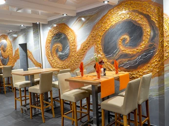 Das Bild zeigt ein Restaurant mit hohen Tischen, barrierefrei zugänglich und stilvoll eingerichtet.