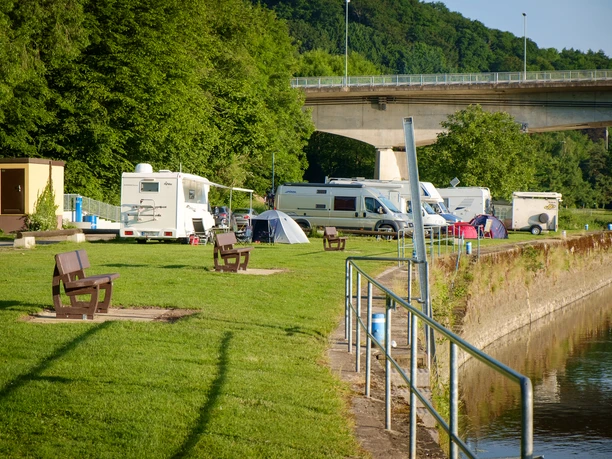 Blick auf das Hafengelände mit Wiese und den dort stehenden Wohnmobilen