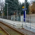 Bahnhof Schloß Neuhaus Ein kleiner Bahnhof mit modernem Wartebereich, Geländer, Bäumen und einem Weg entlang der Gleise.