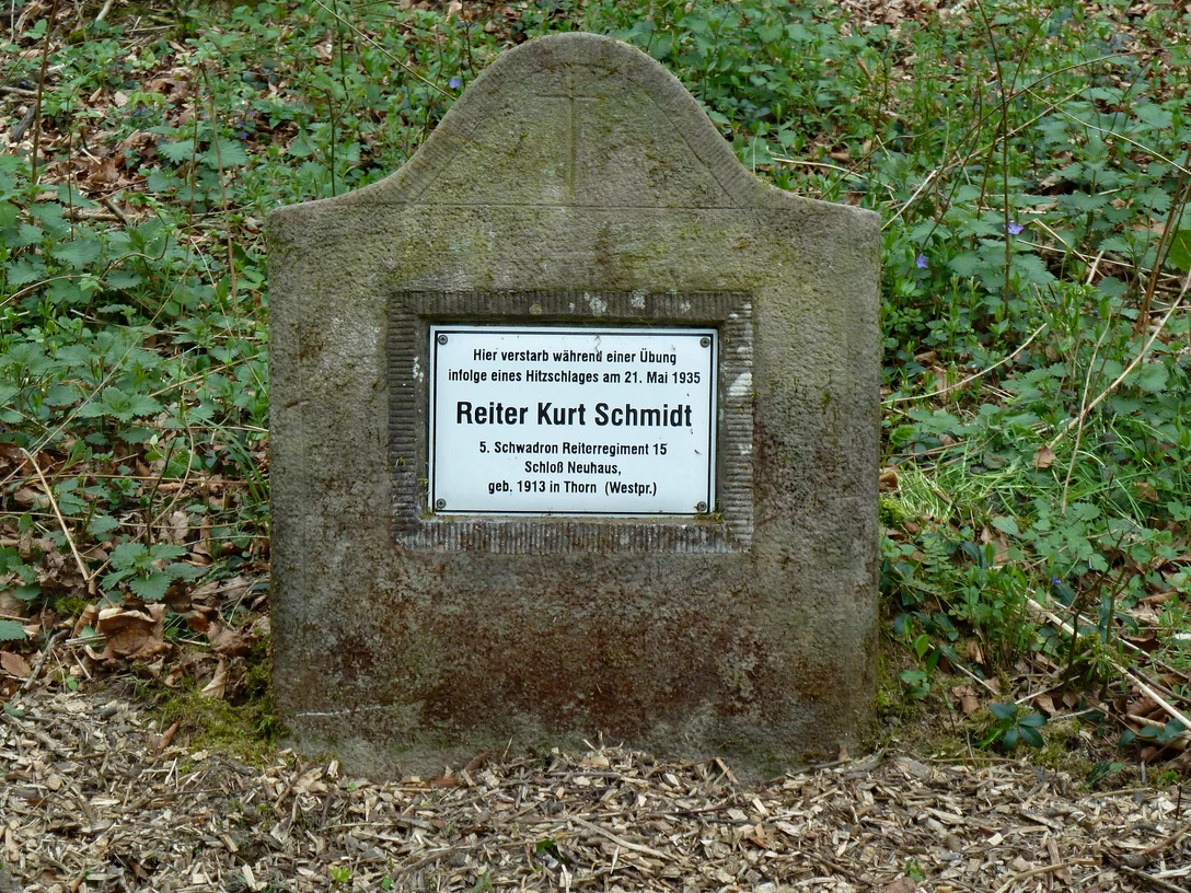 Denkmal für Reiter Kurt Schmidt Gedenkstein für Reiter Kurt Schmidt, umgeben von Laub und Grün, in Waldnähe platziert.