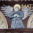 Adam-und-Eva-Haus, Ausschnitt Ein kunstvoll geschnitzter Engel mit goldenem Heiligenschein und detaillierten Flügeln verziert eine Fachwerkfassade.