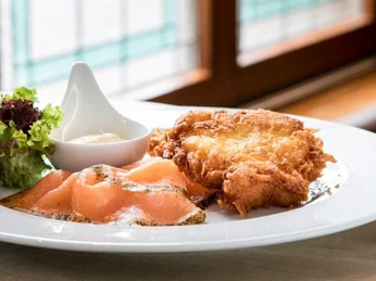 Restaurant Haus Scholzen Ein Teller Reibekuchen mit Lachs und Salat.A plate of potato pancakes with salmon and salad.