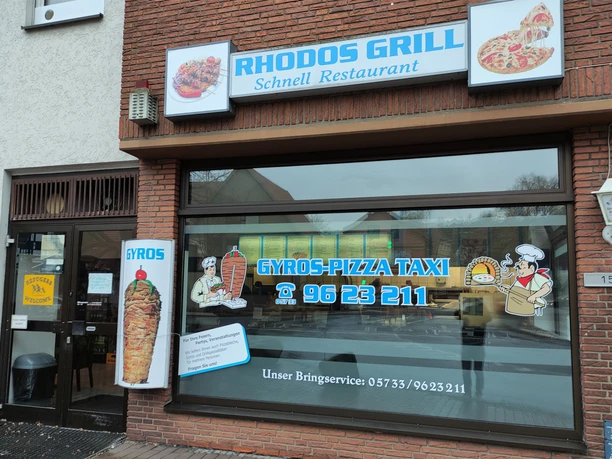 Außenansicht vom Rhodos Grill, auf der Fensterscheibe ist Werbung